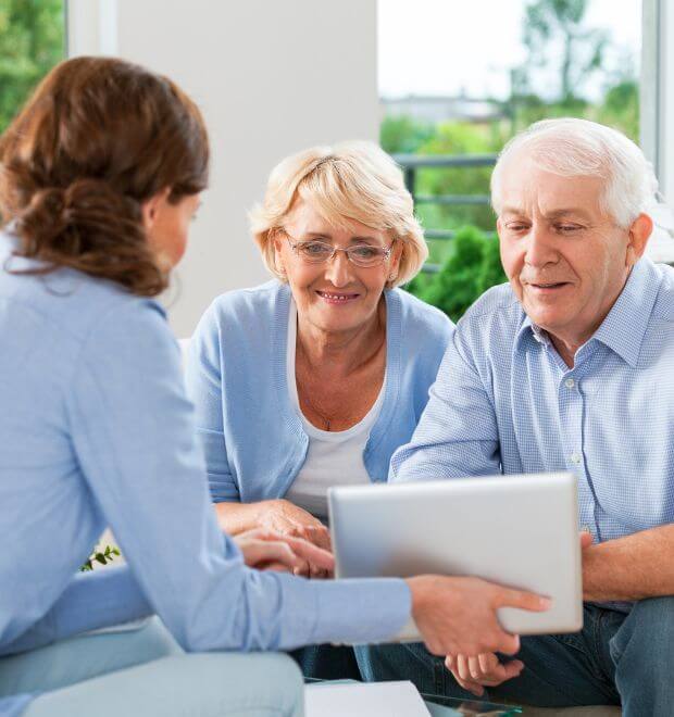 three people sitting down  and one women holding a tablet 